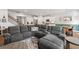 Open-concept living room featuring a large gray sectional sofa, kitchen, dining area, and staircase at 1436 Maston Rd, Auburn, GA 30011