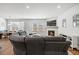 Bright living room features hardwood floors, fireplace, and view into the dining area with a large gray sectional sofa at 1436 Maston Rd, Auburn, GA 30011