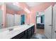 Double vanity bathroom with pink walls leading into a blue painted bedroom at 144 Still Pine Bnd, Smyrna, GA 30082