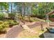 An inviting backyard featuring lush landscaping, a stone staircase, and a pergola-covered patio at 356 Ivy Glen Cir, Avondale Estates, GA 30002