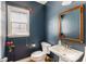 A half bathroom with blue walls, a window, a pedestal sink, and a toilet at 356 Ivy Glen Cir, Avondale Estates, GA 30002