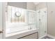 Elegant bathroom featuring a glass-enclosed shower and a soaking tub under a decorative window at 356 Ivy Glen Cir, Avondale Estates, GA 30002