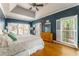 Bright main bedroom with hardwood floors, a tray ceiling, and large windows with white shutters at 356 Ivy Glen Cir, Avondale Estates, GA 30002