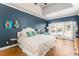 Spacious bedroom with a tray ceiling, an accent wall, and large windows with beautiful outdoor views at 356 Ivy Glen Cir, Avondale Estates, GA 30002