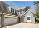 Exterior angle of a beautiful home showing a garage, front door, and landscaping on a sunny day at 356 Ivy Glen Cir, Avondale Estates, GA 30002