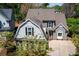 Charming home with gray siding, black shutters, dormer window, and concrete driveway surrounded by mature trees at 356 Ivy Glen Cir, Avondale Estates, GA 30002