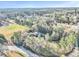 A high aerial view of a home on a wooded lot, set back from a winding country road at 8445 Vernon Grove Rd, Chattahoochee Hills, GA 30268