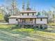 A view of the back of the home highlighting the covered deck and outdoor space at 8445 Vernon Grove Rd, Chattahoochee Hills, GA 30268