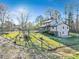 An open green backyard with a partial fence, firepit, and mature trees surrounding the property at 8445 Vernon Grove Rd, Chattahoochee Hills, GA 30268