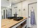 Modern bathroom with double sinks, wood countertop, large mirrors, and stylish fixtures at 8445 Vernon Grove Rd, Chattahoochee Hills, GA 30268