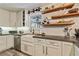 Bright kitchen featuring white cabinets, concrete countertops, open wooden shelves, and modern appliances at 8445 Vernon Grove Rd, Chattahoochee Hills, GA 30268