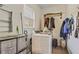 Bright laundry area featuring modern washer, storage containers and handy shelving for efficient organization at 8445 Vernon Grove Rd, Chattahoochee Hills, GA 30268