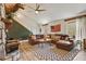 Open concept living room with cozy fireplace and views of the wooded yard at 8445 Vernon Grove Rd, Chattahoochee Hills, GA 30268