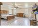 Large primary bedroom with wood floors, ceiling fan, dresser, and large windows at 8445 Vernon Grove Rd, Chattahoochee Hills, GA 30268