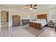 Comfortable bedroom with wood floors, a cozy bed, and a dresser near a crib at 8445 Vernon Grove Rd, Chattahoochee Hills, GA 30268