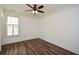 Bright bedroom featuring hardwood floors, ceiling fan, and natural light from the large window at 110 Mountain Laurel Ct, Canton, GA 30114