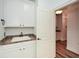 Modern laundry room with white cabinets, sink, and access to a hallway at 110 Mountain Laurel Ct, Canton, GA 30114