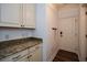 Mud room with granite countertop and white cabinets next to a door with coat hooks at 110 Mountain Laurel Ct, Canton, GA 30114