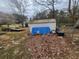 View of the home's backyard area with shed and a trailer on a leaf covered yard at 111 Oak Grove Rd, Temple, GA 30179