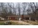 Quaint brick single-story home featuring mature trees, a lawn, and inviting front entrance at 111 Oak Grove Rd, Temple, GA 30179