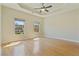 Spacious bedroom with hardwood floors, tray ceiling, ceiling fan, and large windows at 2782 Laurel Valley Trl, Buford, GA 30519