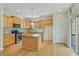 Bright kitchen features wood cabinets, stainless steel appliances, and a kitchen island at 2782 Laurel Valley Trl, Buford, GA 30519