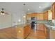 Open kitchen with wood cabinets, stainless appliances, granite counters, and a kitchen island at 2782 Laurel Valley Trl, Buford, GA 30519