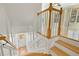 Traditional staircase with white wainscoting, wood railing, and light hardwood floors at 2782 Laurel Valley Trl, Buford, GA 30519