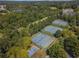 Aerial view showcasing multiple tennis courts nestled within lush greenery and landscaping at 6230 Hampton Highlands Dr, Cumming, GA 30041
