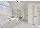 A bright bathroom features an arched window above the tub and a separate glass-enclosed shower at 6230 Hampton Highlands Dr, Cumming, GA 30041
