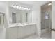 Bright bathroom featuring a double sink vanity with a large mirror and a glass-enclosed shower at 6230 Hampton Highlands Dr, Cumming, GA 30041