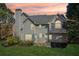Exterior of home showing backyard, patio and lush landscaping at sunset at 6230 Hampton Highlands Dr, Cumming, GA 30041