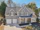 Charming two-story home with a two-car garage, stone accents, and a welcoming covered front porch at 6230 Hampton Highlands Dr, Cumming, GA 30041