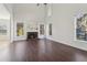Inviting living room featuring hardwood floors, a stone fireplace, and ample natural light at 6230 Hampton Highlands Dr, Cumming, GA 30041
