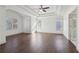An empty main bedroom boasts tray ceilings, dark hardwood floors, and has large windows for natural light at 6230 Hampton Highlands Dr, Cumming, GA 30041