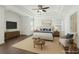 A bright main bedroom features tray ceilings, a ceiling fan and is virtually staged with furniture at 6230 Hampton Highlands Dr, Cumming, GA 30041