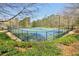 Enjoy a match on the well-maintained community tennis court, surrounded by lush landscaping and secure fencing at 6230 Hampton Highlands Dr, Cumming, GA 30041