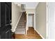 Bright foyer featuring hardwood floors and a staircase with a wooden railing at 1952 Appaloosa Mill Cir, Buford, GA 30519