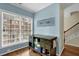 Hallway of home with hardwood floors, window view, decorated accent wall, and access to the staircase at 1952 Appaloosa Mill Cir, Buford, GA 30519