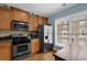 Modern kitchen with stainless steel appliances, a window view, and wood cabinets for ample storage and functionality at 1952 Appaloosa Mill Cir, Buford, GA 30519