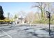 The tennis court is near the house and is framed by trees with yellow flowers at 2211 Surrey Se Ct, Marietta, GA 30067