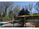 The tennis court is near a gazebo and is framed by trees with yellow flowers at 2211 Surrey Se Ct, Marietta, GA 30067