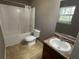 Bathroom featuring a shower-tub, toilet, and single sink vanity beneath a window at 2938 Palm Dr, Atlanta, GA 30344