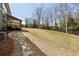Backyard featuring stone pathway to the deck with a spacious grassy area and mature trees at 3878 Amicus Dr, Buford, GA 30519