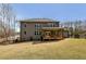 Backyard showcasing a large grassy area and a home with multiple windows and a covered porch at 3878 Amicus Dr, Buford, GA 30519