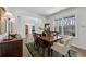 Elegant dining room with a wooden table set for six, complemented by a large window at 3878 Amicus Dr, Buford, GA 30519