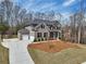 Spacious two-story home with a brick facade, three-car garage, and expansive driveway at 3878 Amicus Dr, Buford, GA 30519