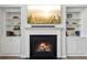 Elegant fireplace with built-in bookcases featuring a TV and decorative shelving at 3878 Amicus Dr, Buford, GA 30519