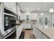 Bright, modern kitchen featuring white cabinets, stainless steel appliances, granite countertops, and hardwood floors at 3878 Amicus Dr, Buford, GA 30519