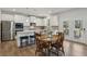 Eat-in kitchen features white cabinets, stainless appliances, and an island for casual dining at 3878 Amicus Dr, Buford, GA 30519